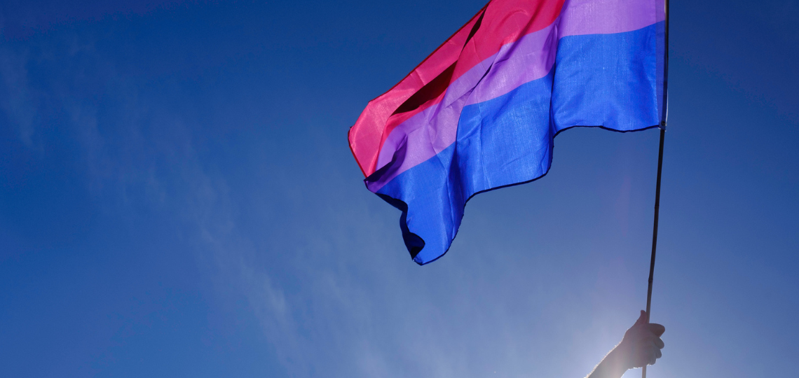 Una bandera bisexual ondeando en el cielo