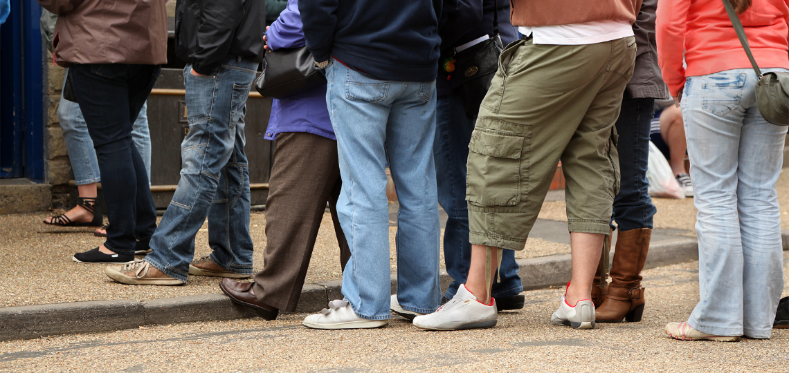 Imagen de varias personas guardando una cola
